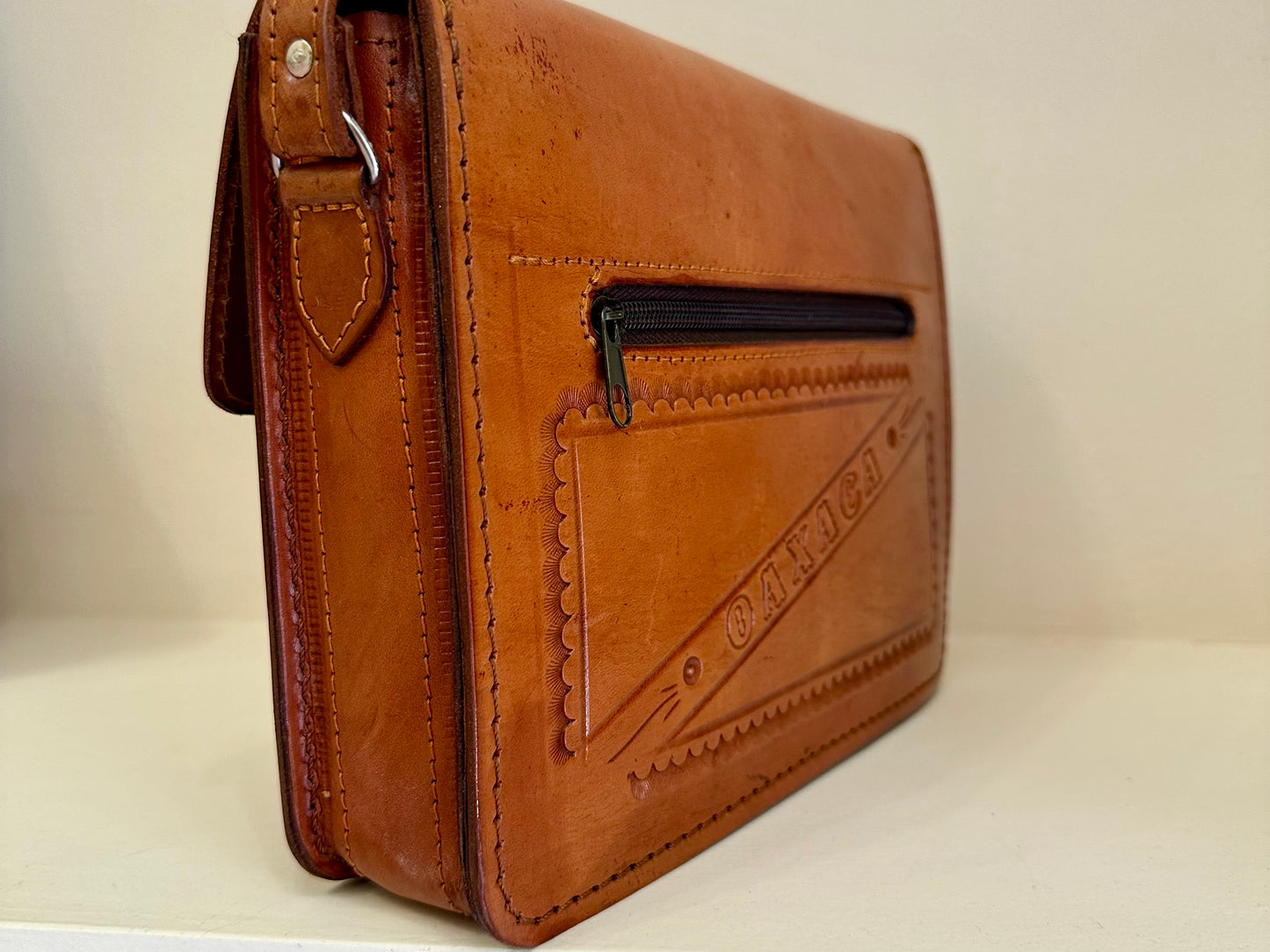 Bolso tipo clutch de cuero cruzado cincelado a mano